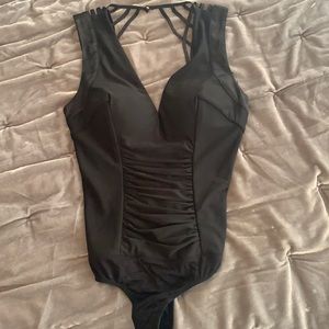 NWT Black one piece Bebe body suit, plunge front ,strappy zipper back .